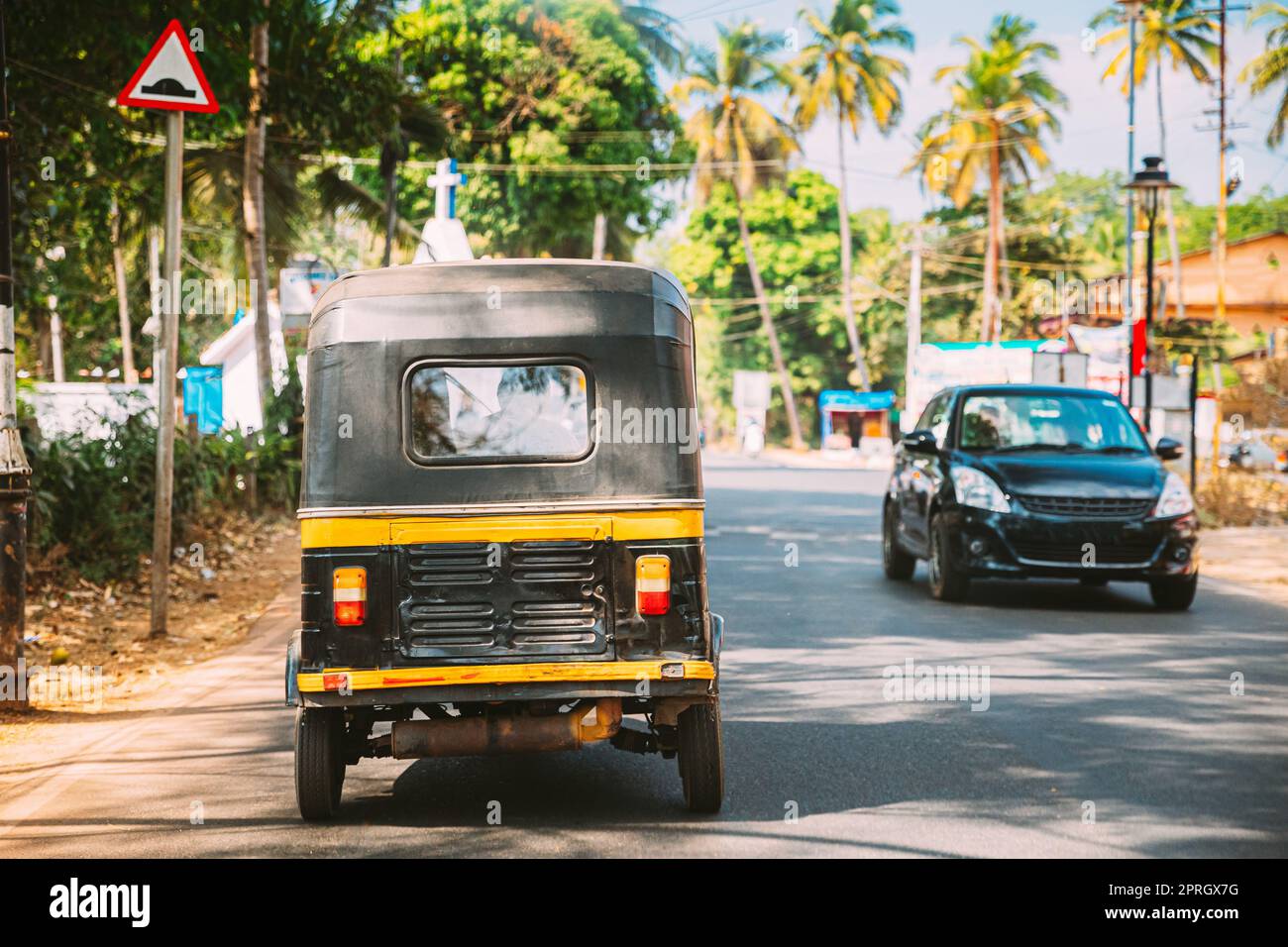 Goa, India. Risciò automatico o tuk-tuk che si muovono sulla strada. Vista posteriore Foto Stock