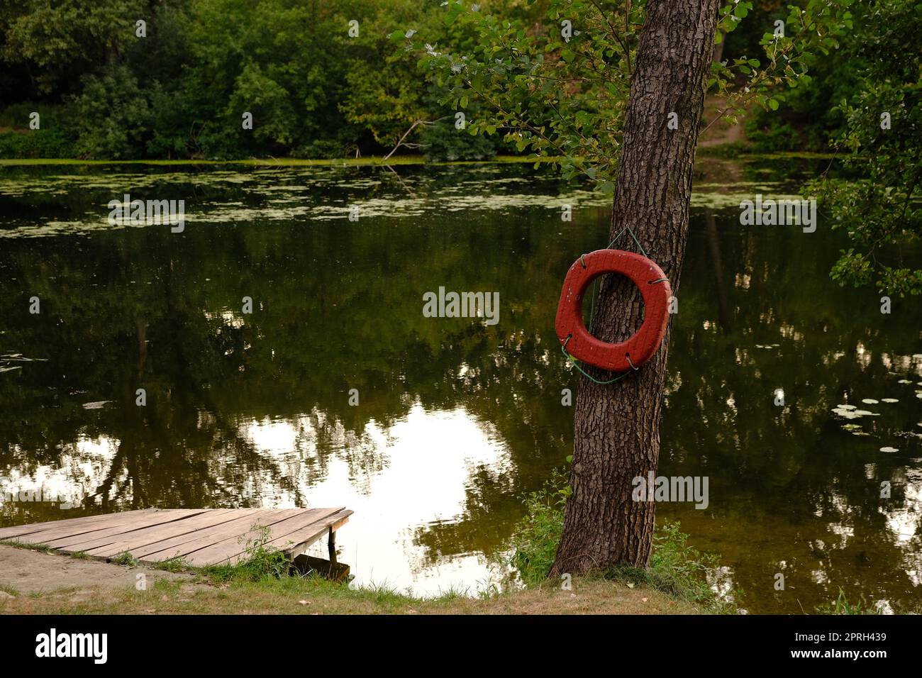 Anello di salvataggio sull'ormeggio del fiume con molo in legno all'aperto Foto Stock