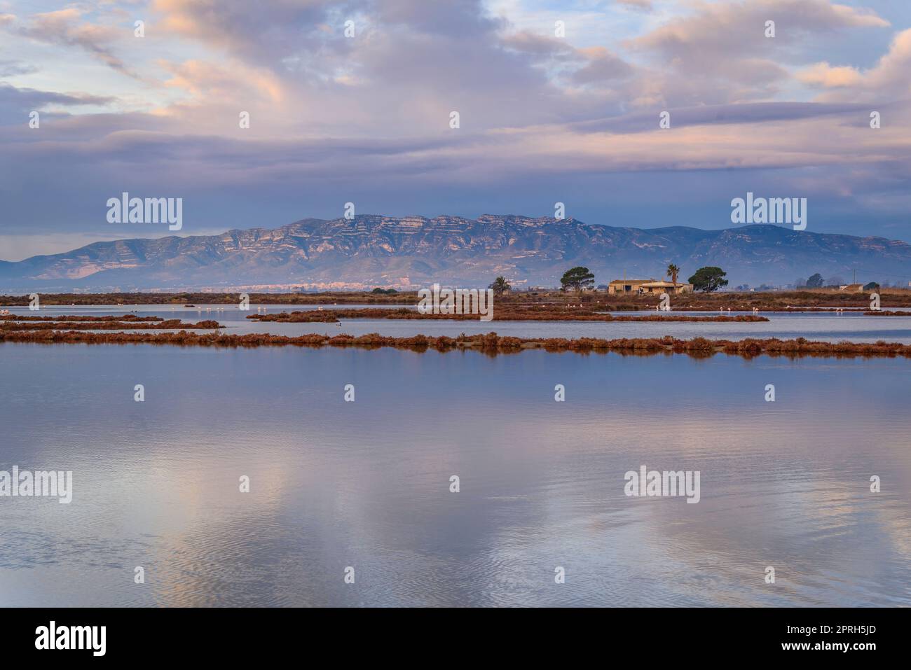 Montsià catena montuosa vista da vicino all'istmo barra del Trabucador con la sua riflessione sulle acque della baia di Alfacs nel Delta Ebro (Spagna) Foto Stock