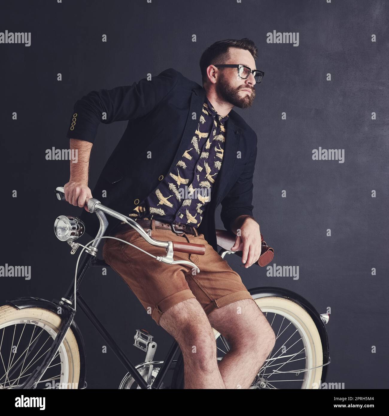 Io indossi il mio stile, il mio modo, un giovane alla moda che si posa in studio con la sua bicicletta. Foto Stock