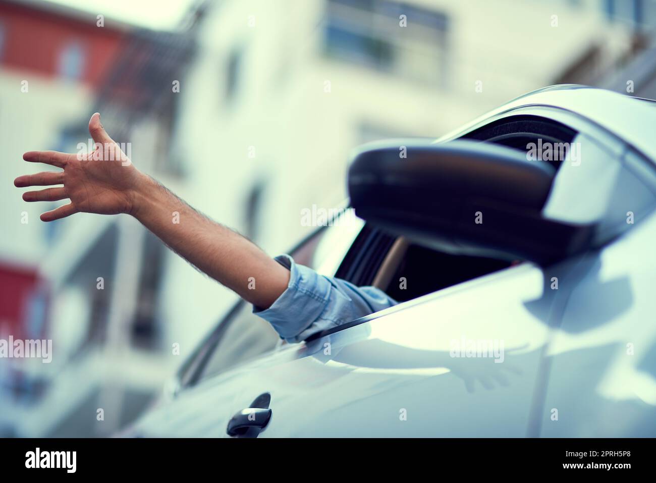 Senso di libertà. Una persona irriconoscibile che guida in auto mentre si stacca la mano dal finestrino. Foto Stock