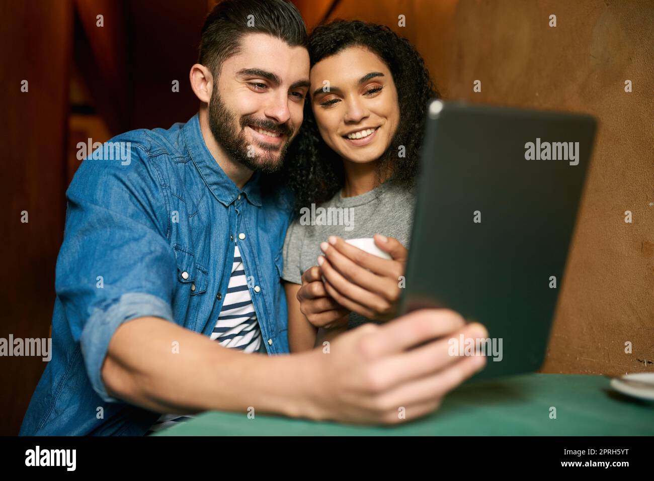 Il nostro tempo libero è quasi trascorso insieme: Una giovane coppia prende un selfie in un bar. Foto Stock