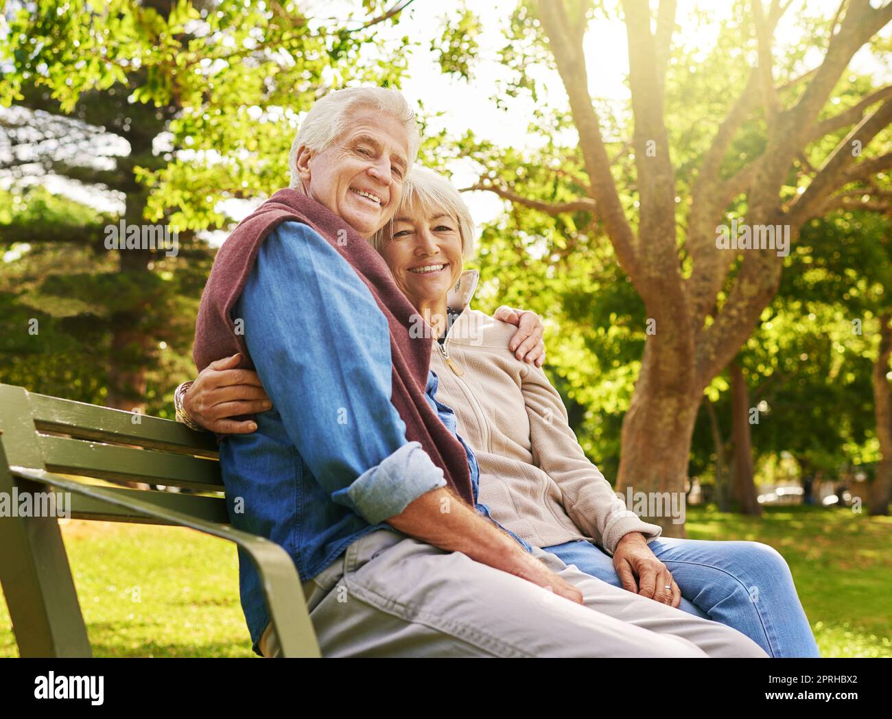 Il relax inizia ora. Ritratto di una felice coppia anziana che si rilassa su una panchina del parco. Foto Stock