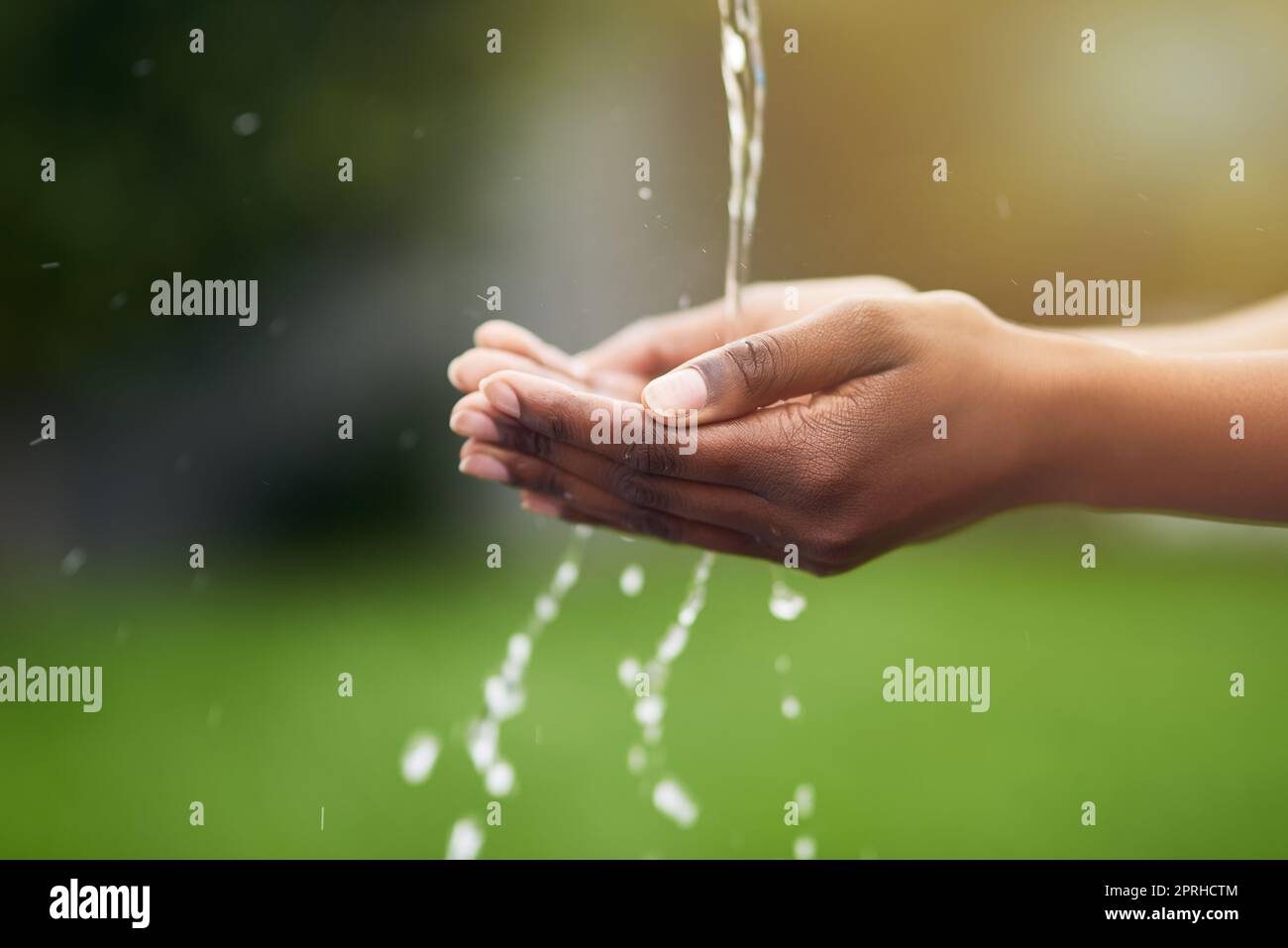 L'acqua è vita, una donna che si lava le mani all'aperto. Foto Stock