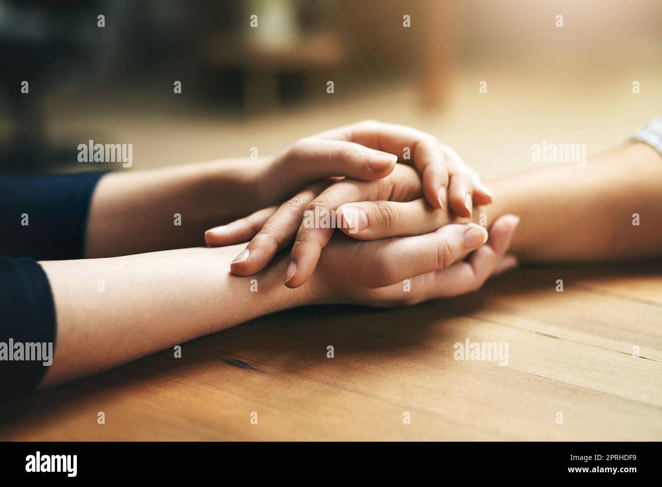 Piccoli gesti di gentilezza vanno molto. Primo piano di due persone non identificabili che tengono le mani in comodità. Foto Stock