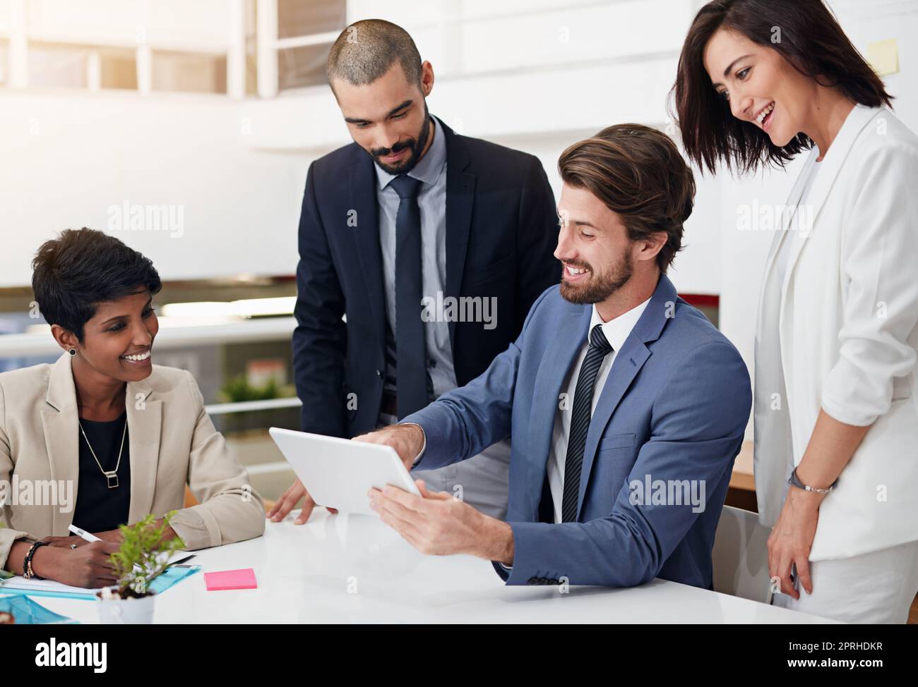 Collaborazione per raggiungere il successo. Gli uomini d'affari utilizzano un tablet digitale in una riunione d'ufficio. Foto Stock