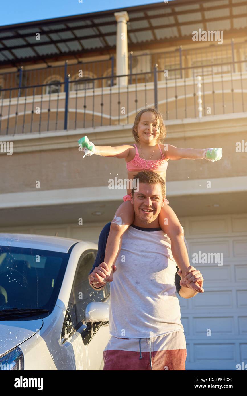Sentirsi in cima al mondo. Ritratto di un padre che porta la figlia sulle spalle. Foto Stock