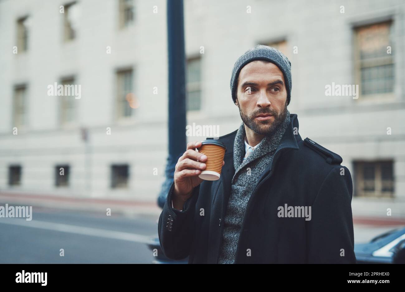 Le buone giornate iniziano con il caffè, un giovane alla moda in un ambiente urbano. Foto Stock