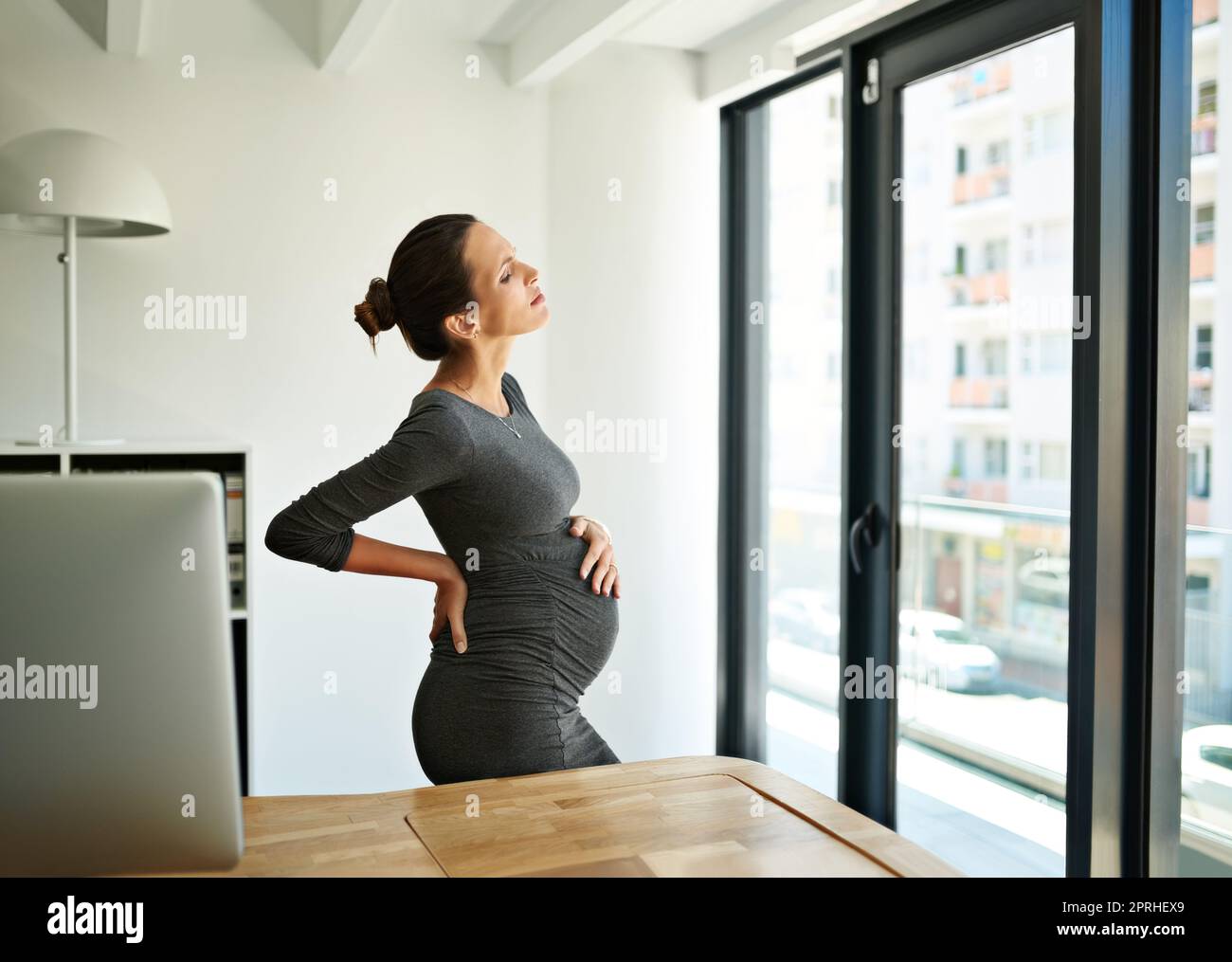 Pronto per il congedo di maternità. Una donna d'affari incinta in disagio nel suo ufficio. Foto Stock
