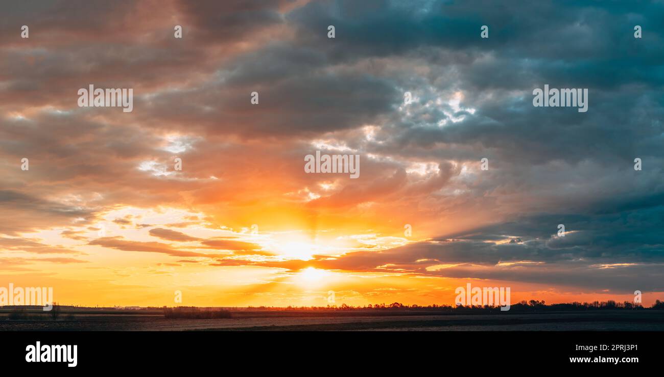 Il sole splende durante il tramonto sopra l'vuota campagna primaverile paesaggio rurale del suolo. Sotto Sunny Spring Sky. Paesaggio agricolo con spazio di copia. Panorama Foto Stock