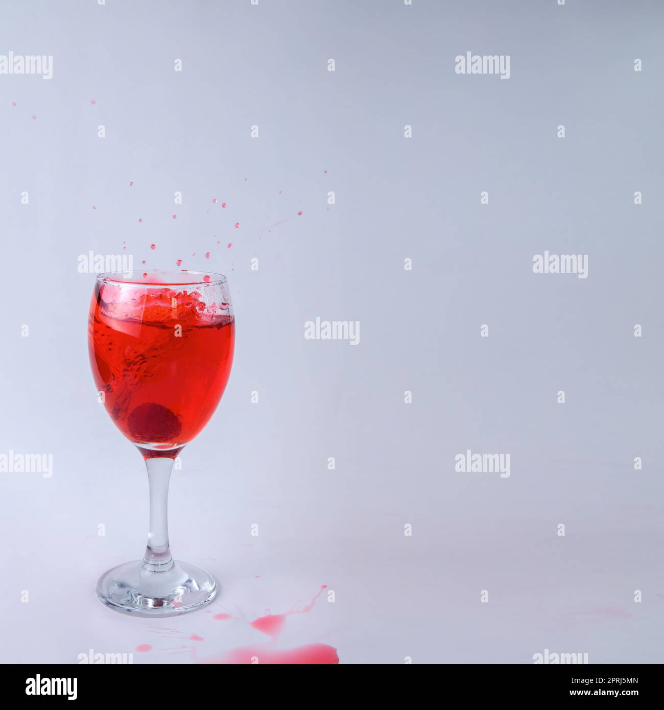 mix di frutti di lampone bicchiere di vino rosso liquido frutta spruzzare bacca su sfondo bianco Foto Stock