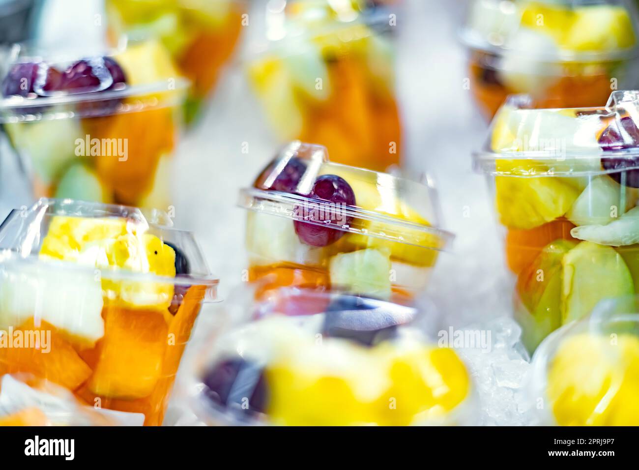 Macedonie di frutta preconfezionate esposte in un frigorifero commerciale Foto Stock