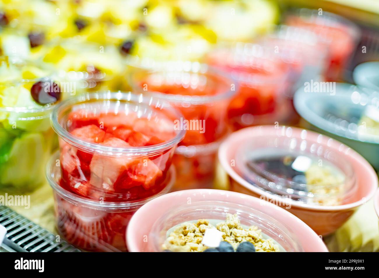 Macedonie di frutta preconfezionate esposte in un frigorifero commerciale Foto Stock