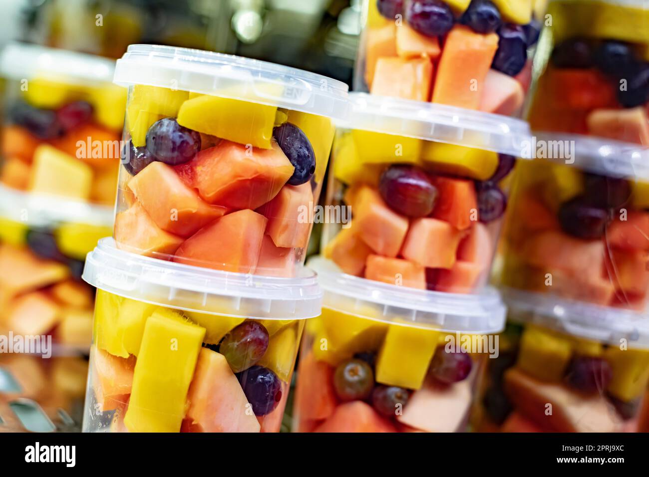 Macedonie di frutta preconfezionate esposte in un frigorifero commerciale Foto Stock