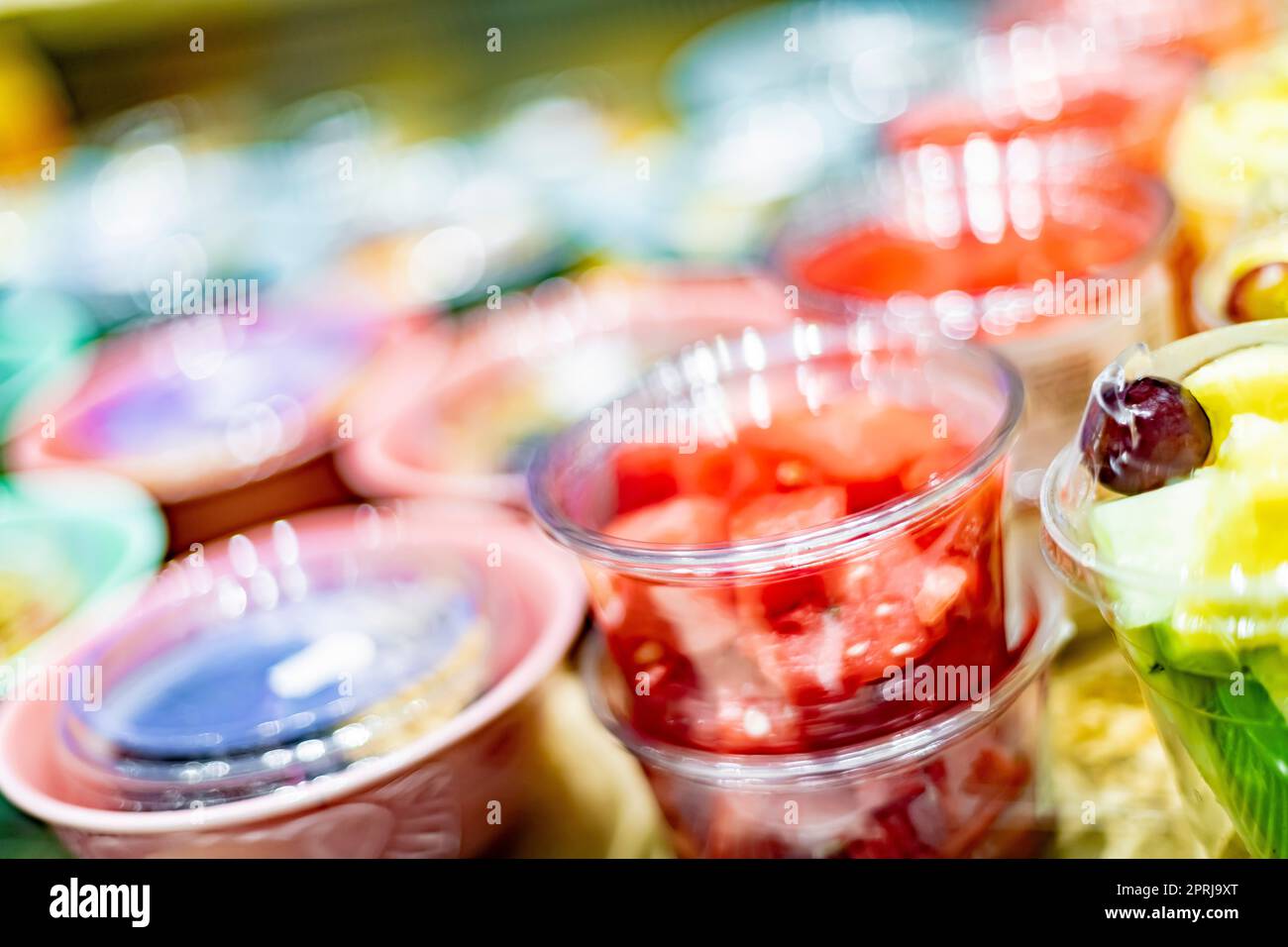 Macedonie di frutta preconfezionate esposte in un frigorifero commerciale Foto Stock