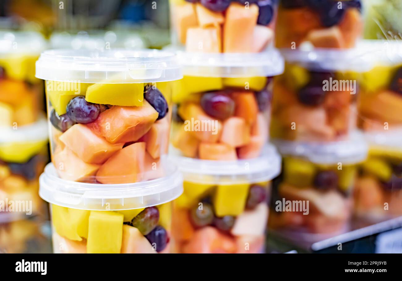 Macedonie di frutta preconfezionate esposte in un frigorifero commerciale Foto Stock