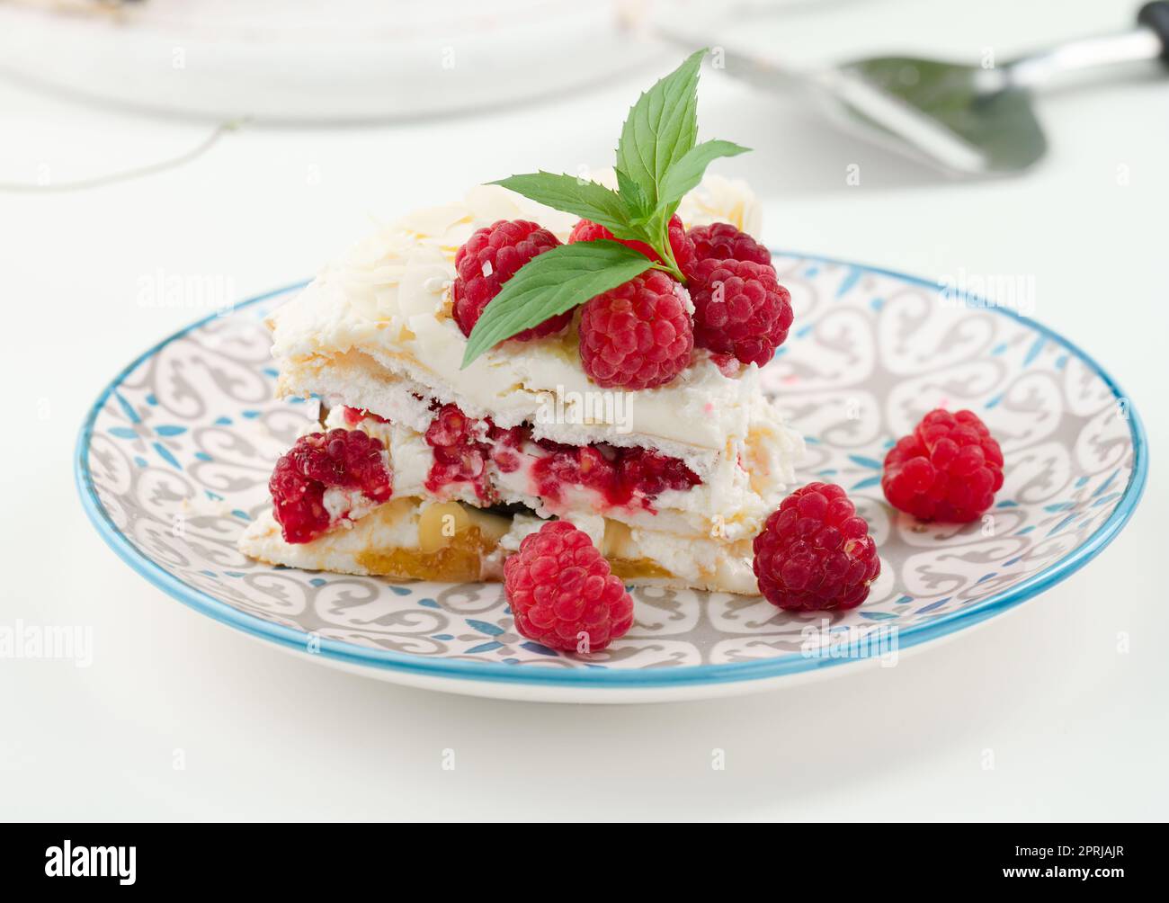 Torta di meringa rotonda con lamponi freschi su sfondo bianco, Pavlova dessert Foto Stock