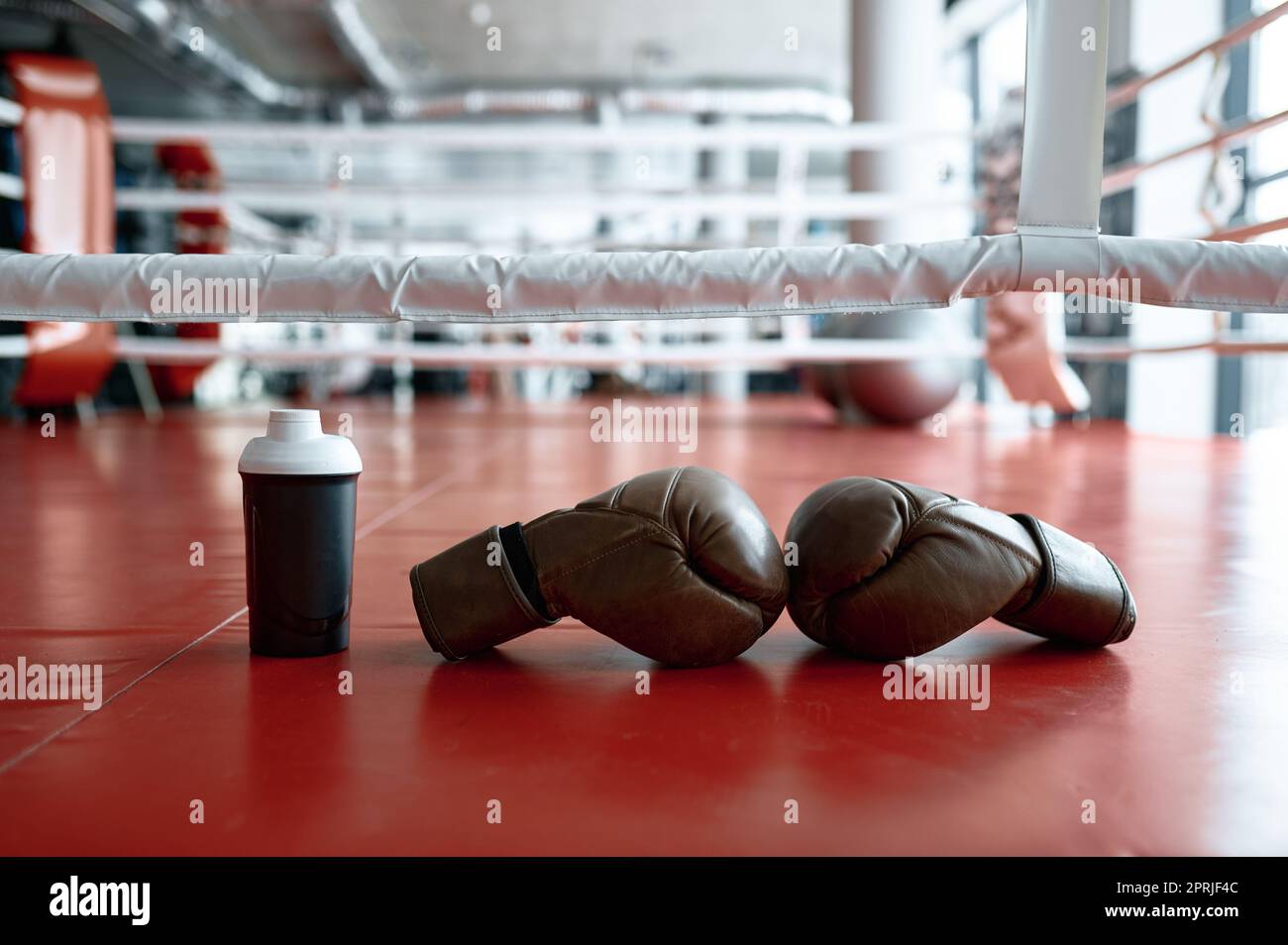 Guanti da boxe e bottiglia d'acqua sull'anello Foto Stock