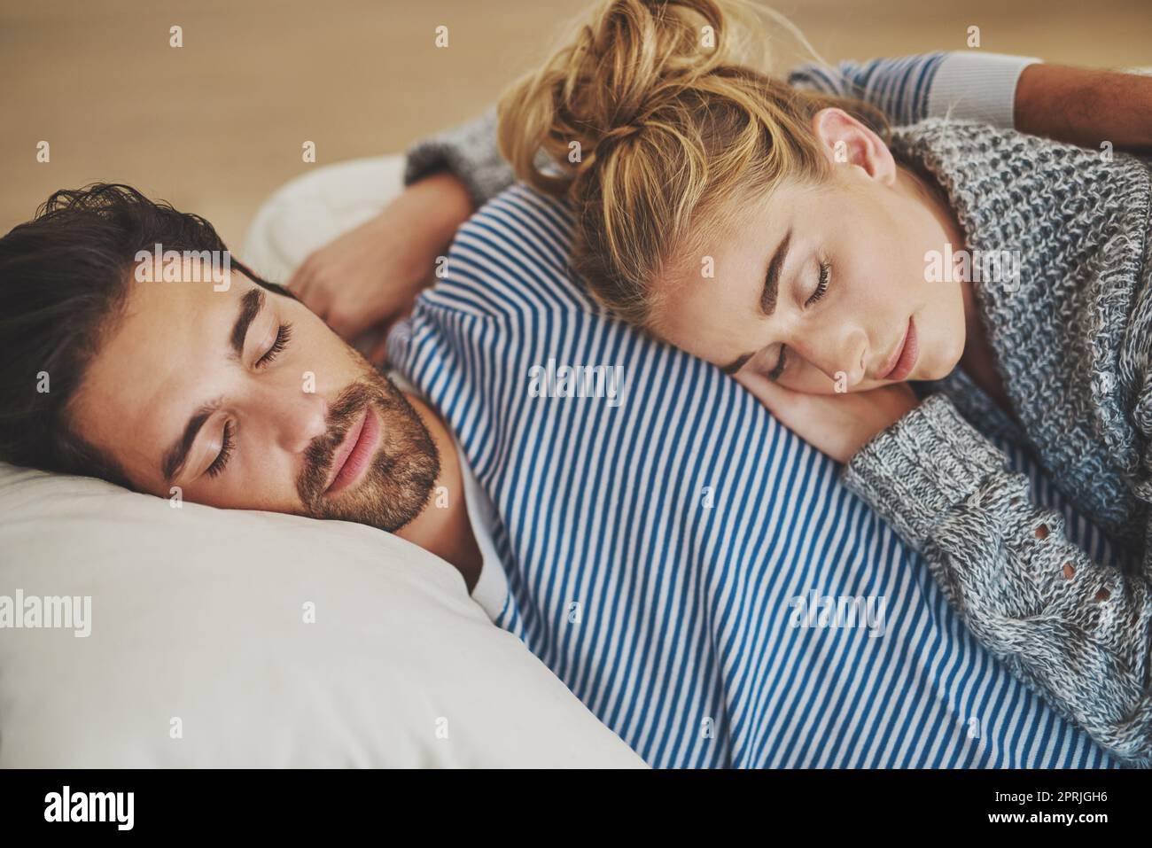 Domenica pomeriggio sonno. Giovane coppia che ha un pisolino insieme sul divano a casa. Foto Stock