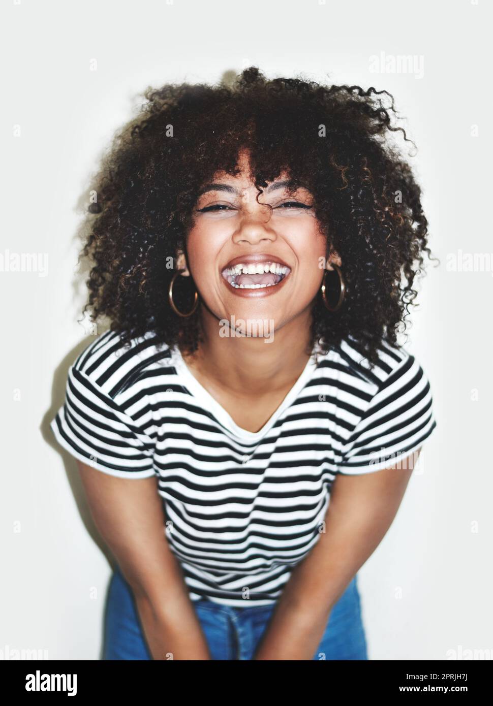 Scoppiare di felicità. Foto studio di una giovane donna felice che si posa su uno sfondo grigio. Foto Stock