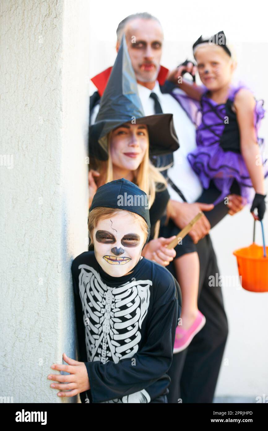 Theyre che si dirige per la vostra porta. Una famiglia carina vestita in su per Halloween che si sneaking fino a voi per spaventare voi Foto Stock