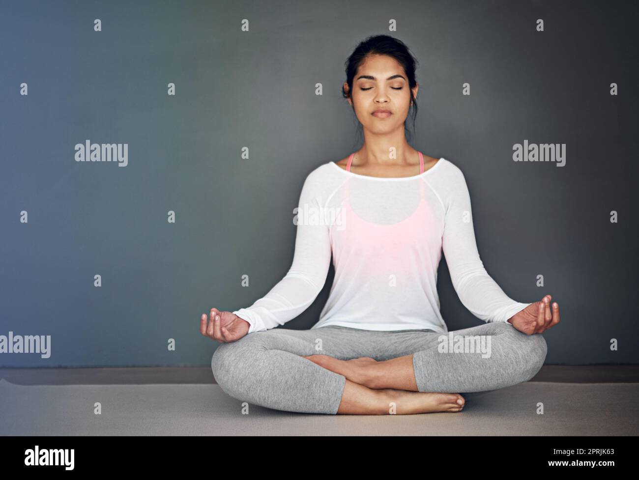 Creare la propria calma. Una giovane donna attraente meditare. Foto Stock