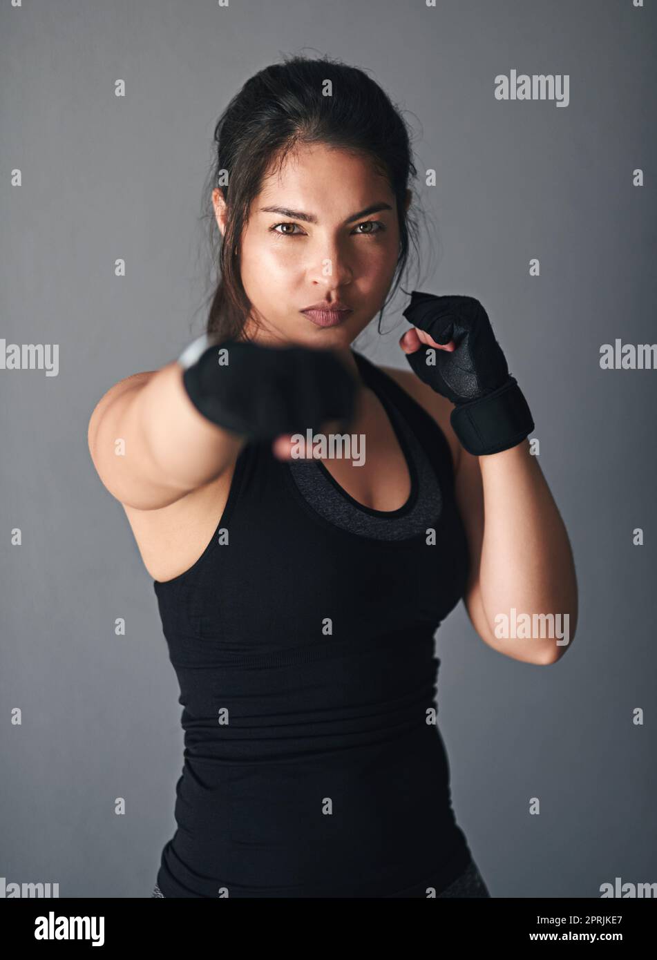 Forma perfetta. Foto studio di un kickboxer femminile su sfondo grigio. Foto Stock