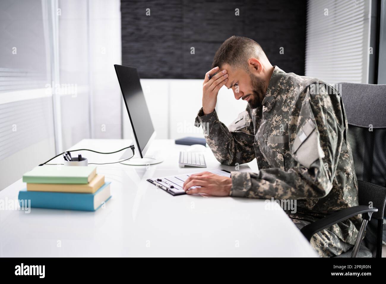 Triste studente veterano militare frustrata che fa test Foto Stock