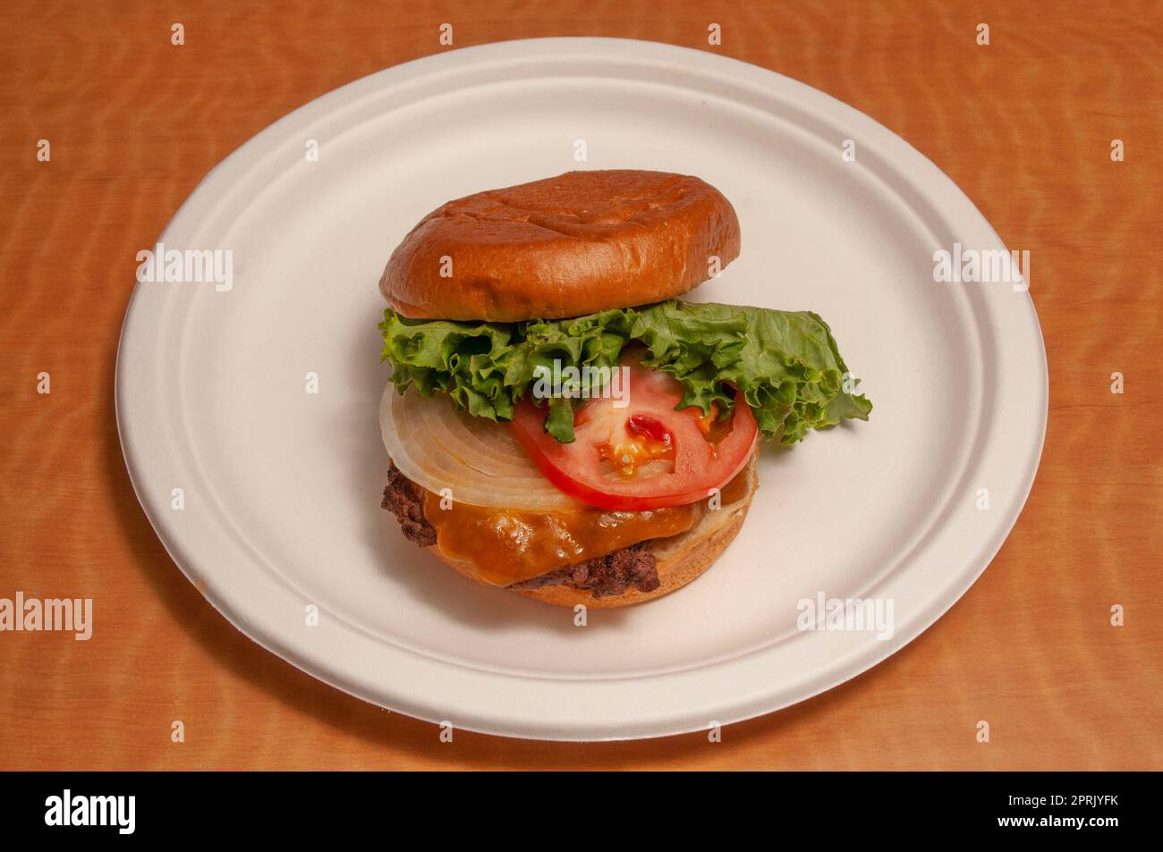 Delizioso cheeseburger con tutti i fissaggi su un panino Foto Stock