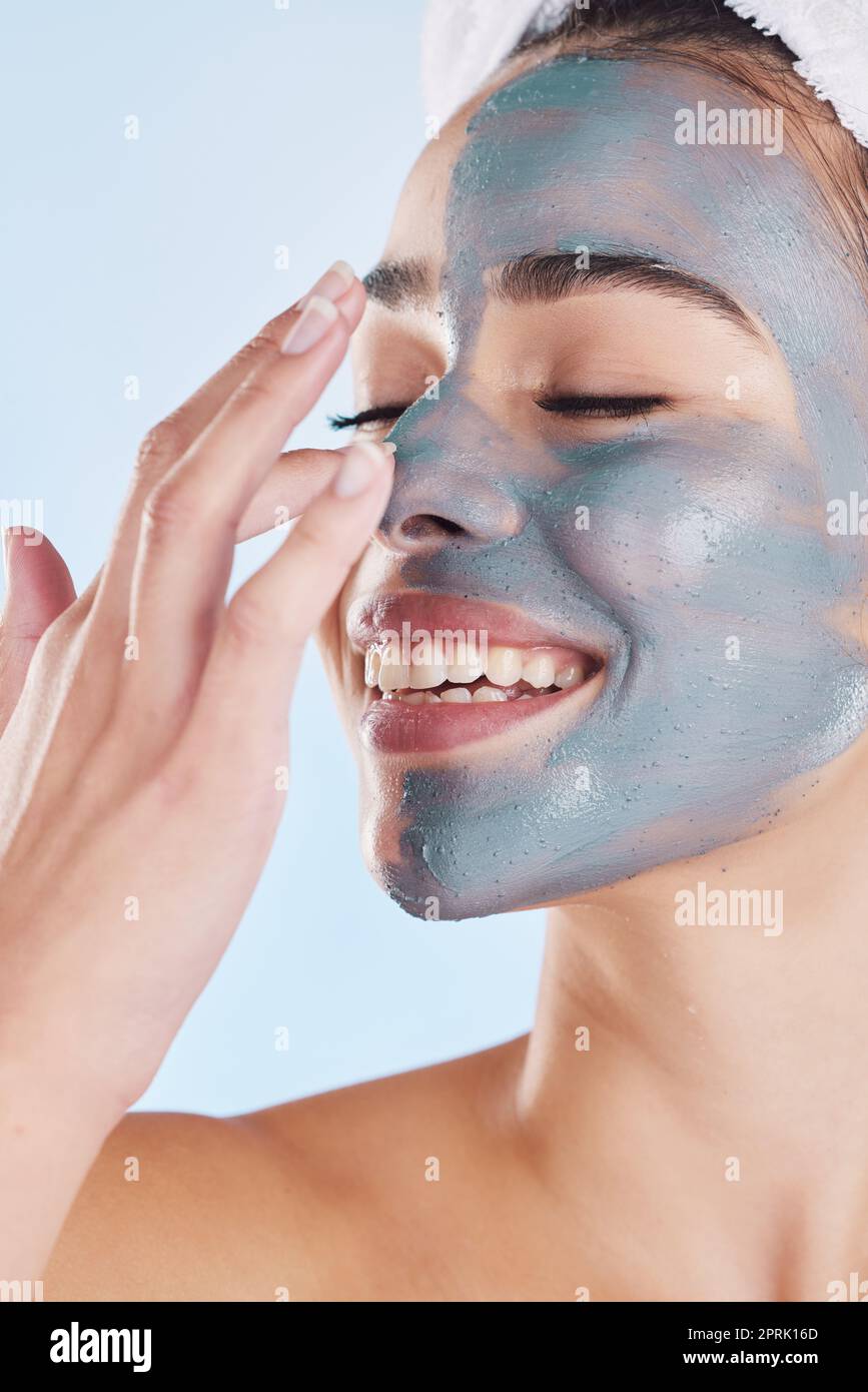 Carbone maschera viso per la cura della pelle di bellezza, prodotto  naturale per la pelle sana e benessere cosmetico pulito per il corpo contro  sfondo blu mockup studio. Felice, sorriso e assistenza