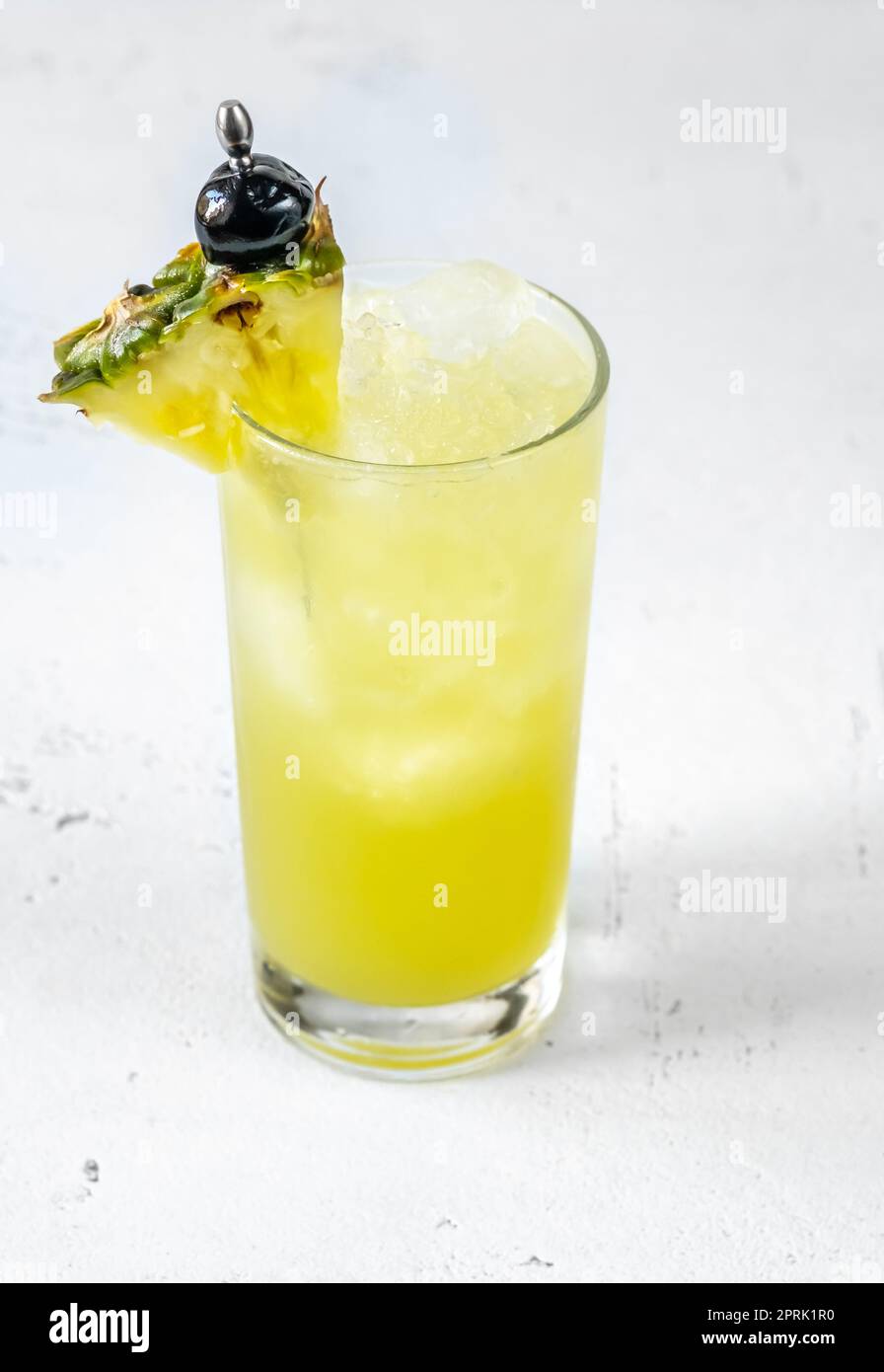 Bicchiere di cocktail Chartreuse Swizzle guarnito con spicchio di ananas Foto Stock