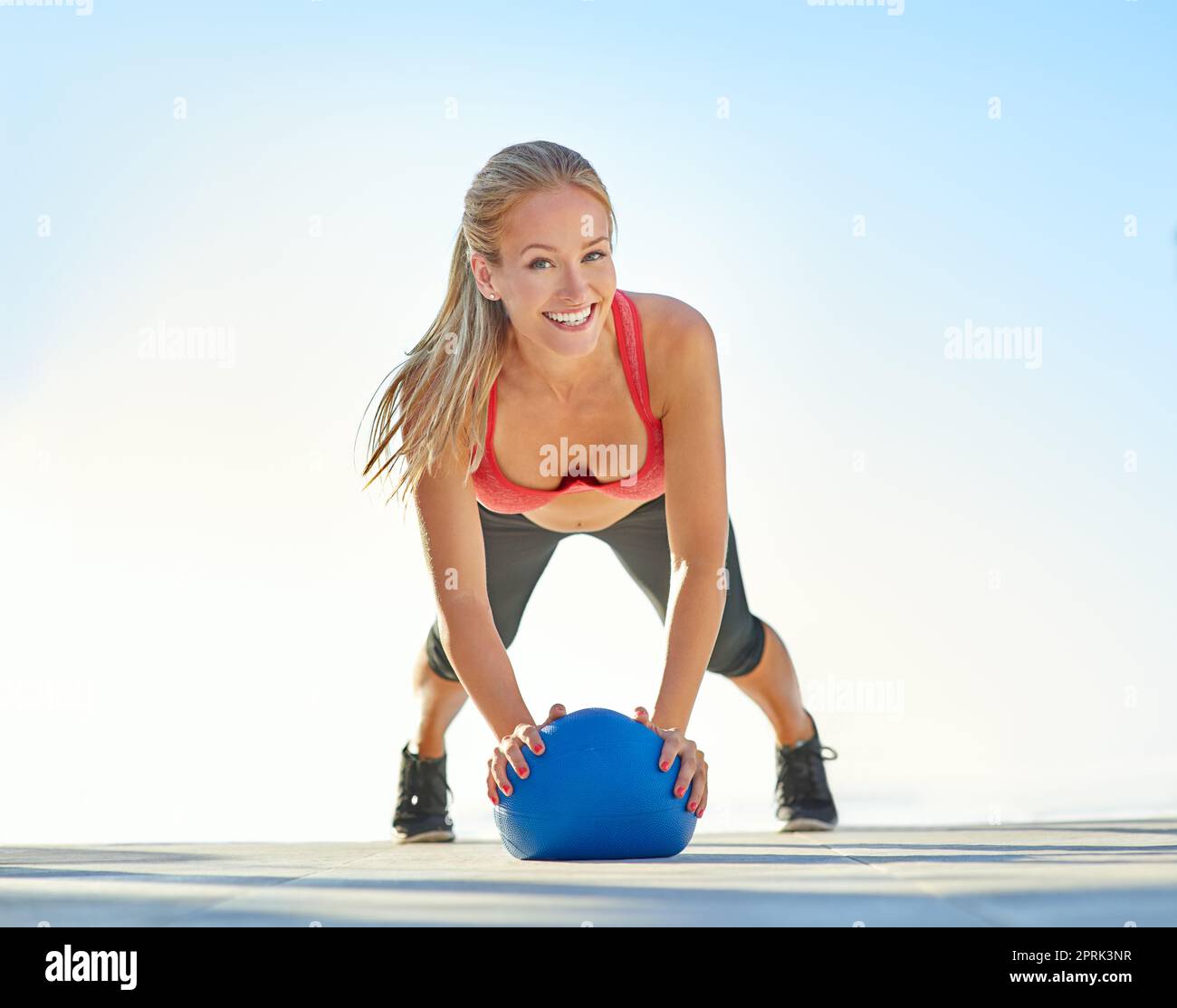 Trovo così tanto divertimento nel fitness. Ritratto completo di una giovane donna che fa pushup con una palla medica. Foto Stock