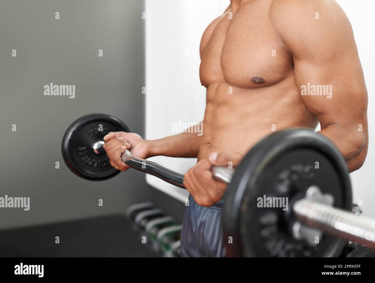 Creare la definizione perfetta del muscolo. Un uomo che fa l'addestramento del peso in una palestra Foto Stock