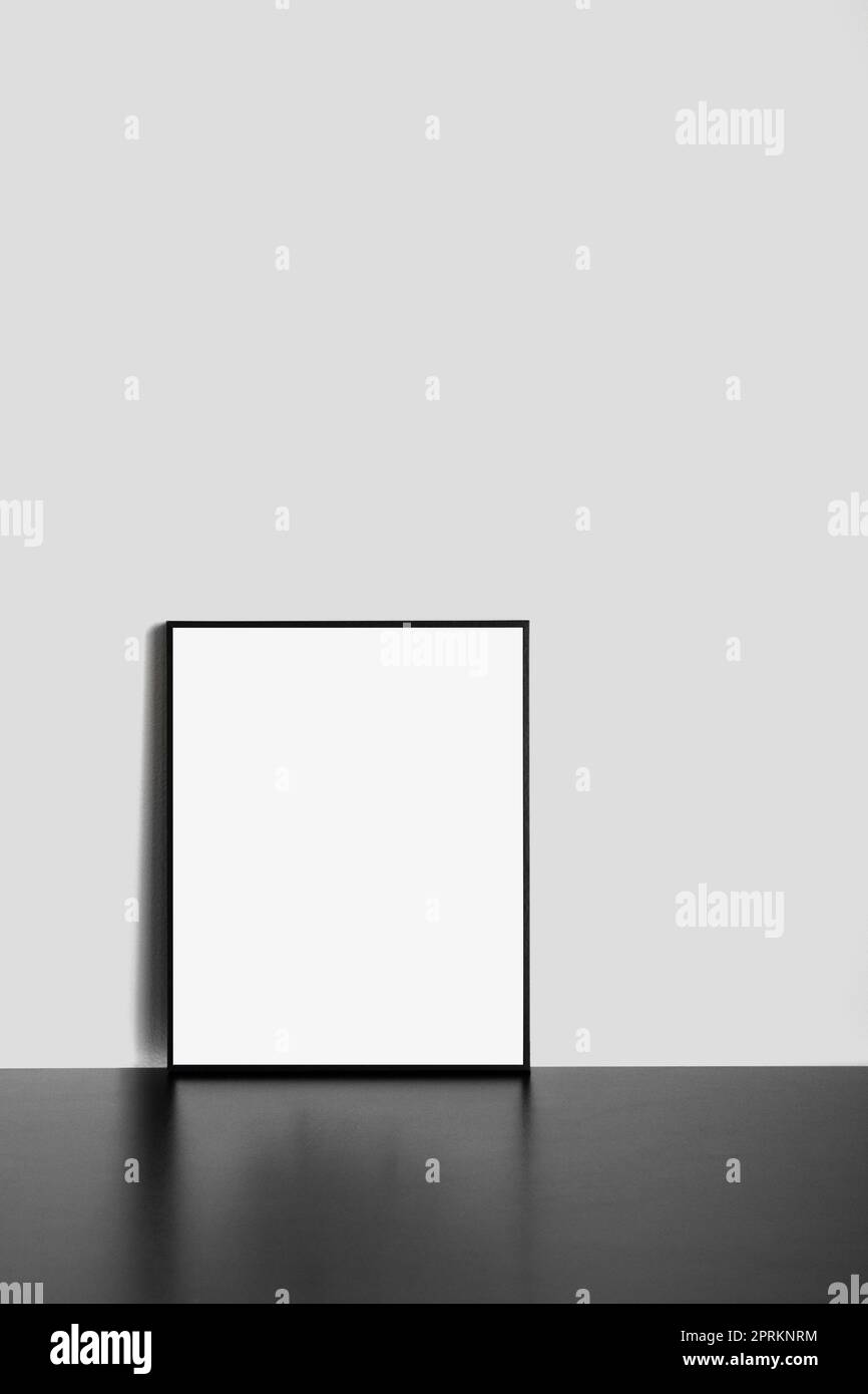Cornice vuota nera mockup su tavolo nero con sfondo bianco Foto Stock