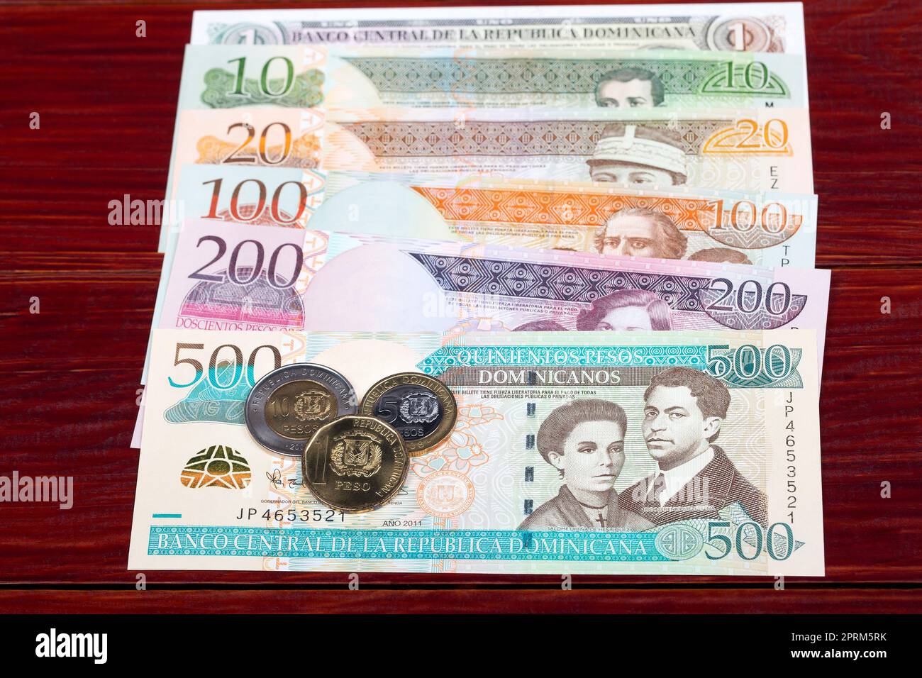 Monete e banconote dominicane pesos su sfondo di legno, serie più vecchia Foto Stock