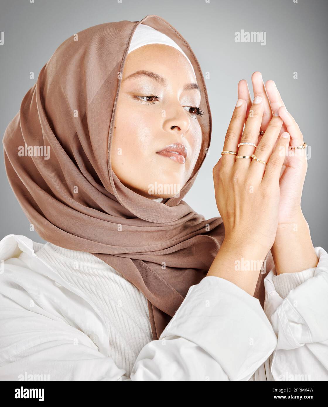 Hijab, gioielli e moda di donna in islam beauty headshot con trucco o cosmetici in uno studio mock up. Modello arabo, musulmano o arabo con sciarpa Foto Stock