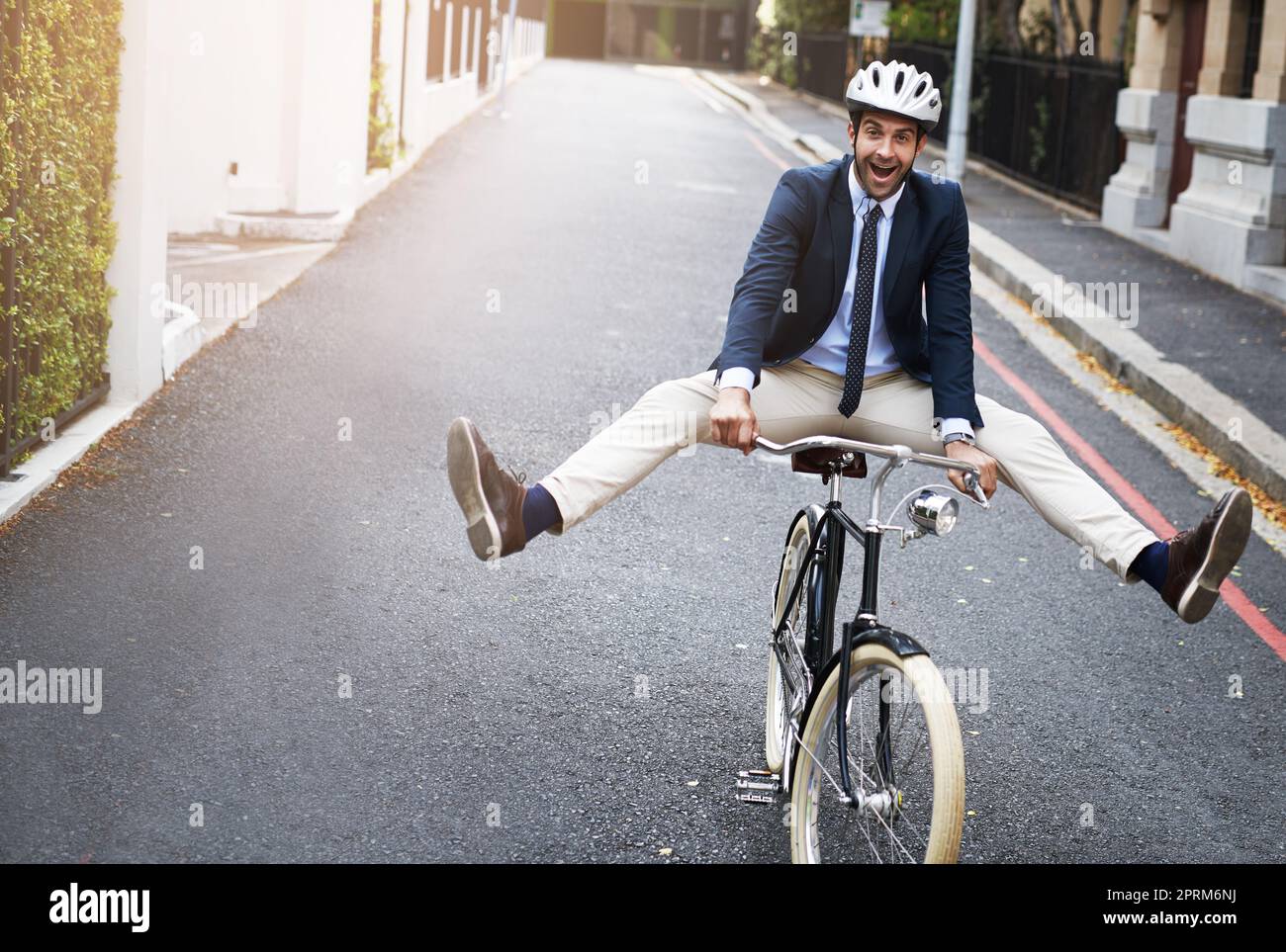 Tentare alcuni trucchi in bicicletta. un bel giovane uomo d'affari in bicicletta per lavorare al mattino Foto Stock