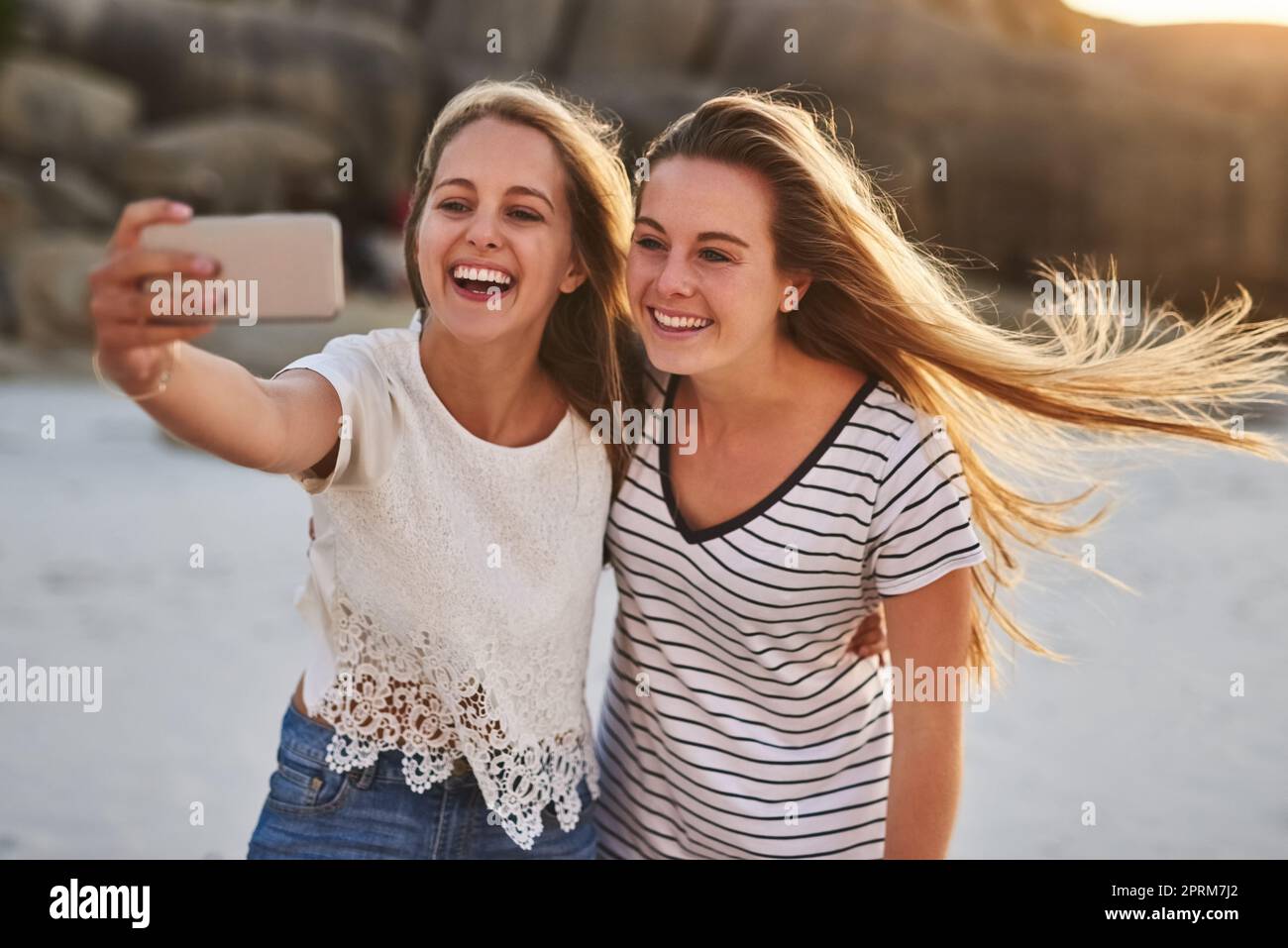 Sorridi per il tuo selfie. due amici prendono un selfie mentre trascorrono la giornata in spiaggia Foto Stock
