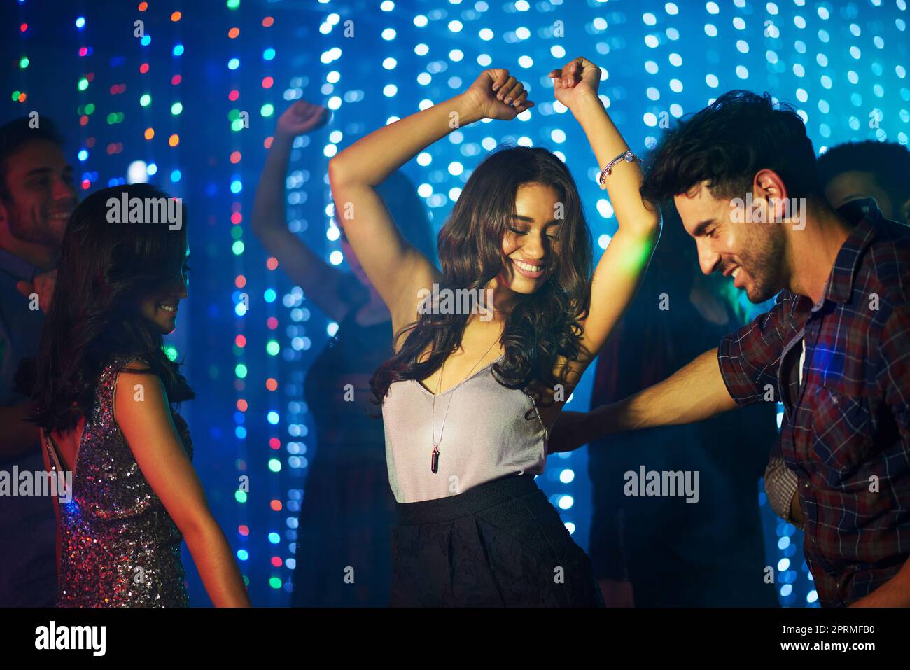 Amo questa canzone, un gruppo di giovani che si divertono sulla pista da ballo in un night club. Foto Stock
