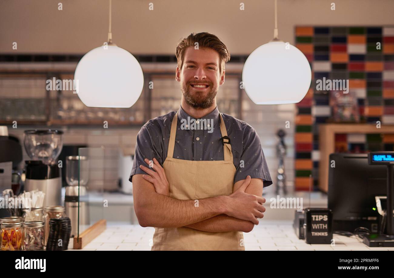 Ci vuole un duro lavoro per vivere i tuoi sogni. Un bel giovane che lavora in un bar. Foto Stock