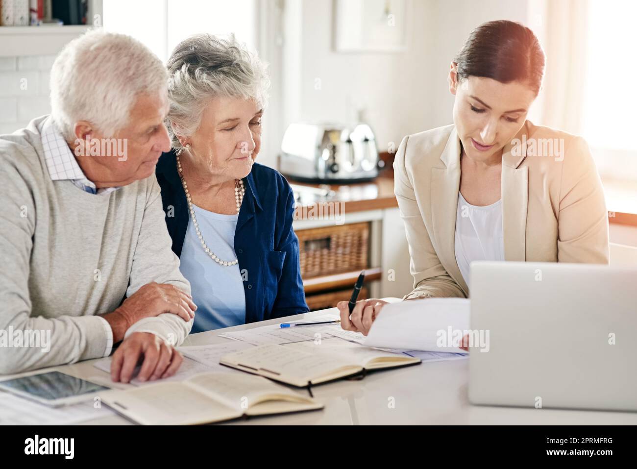 Aiutandoli a trovare i sensi fare il loro risparmio ultimo. Una coppia anziana che ottiene il consiglio dal loro consulente finanziario. Foto Stock