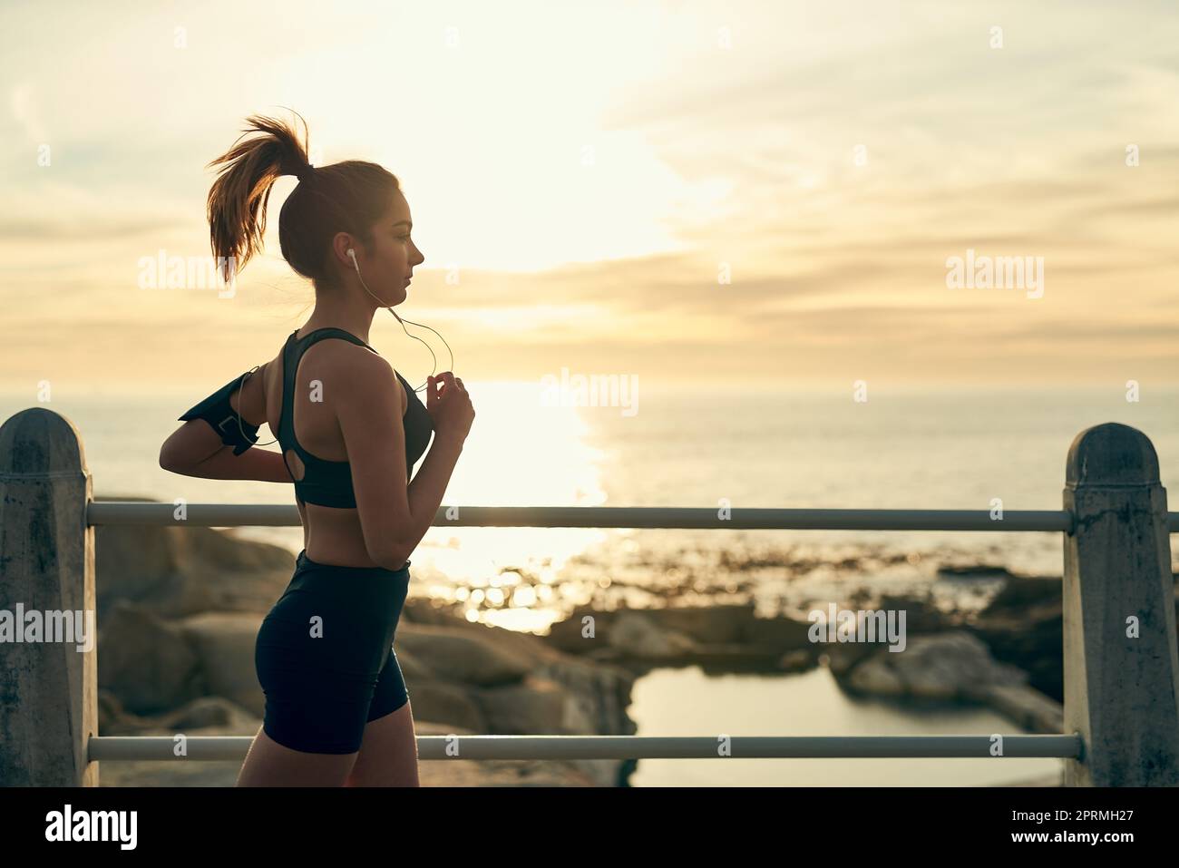 La corsa non ha mai mancato di darmi grandi risultati finali. Una giovane donna sportiva che corre lungo la spianata. Foto Stock