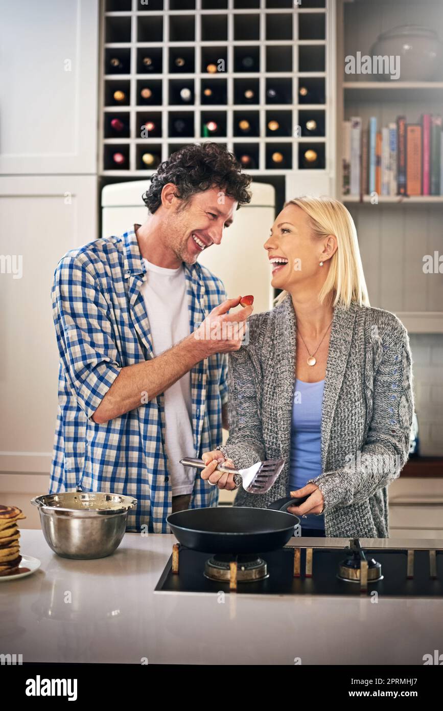 In cucina ci sono cose buone, una coppia felice che fa colazione insieme a casa. Foto Stock