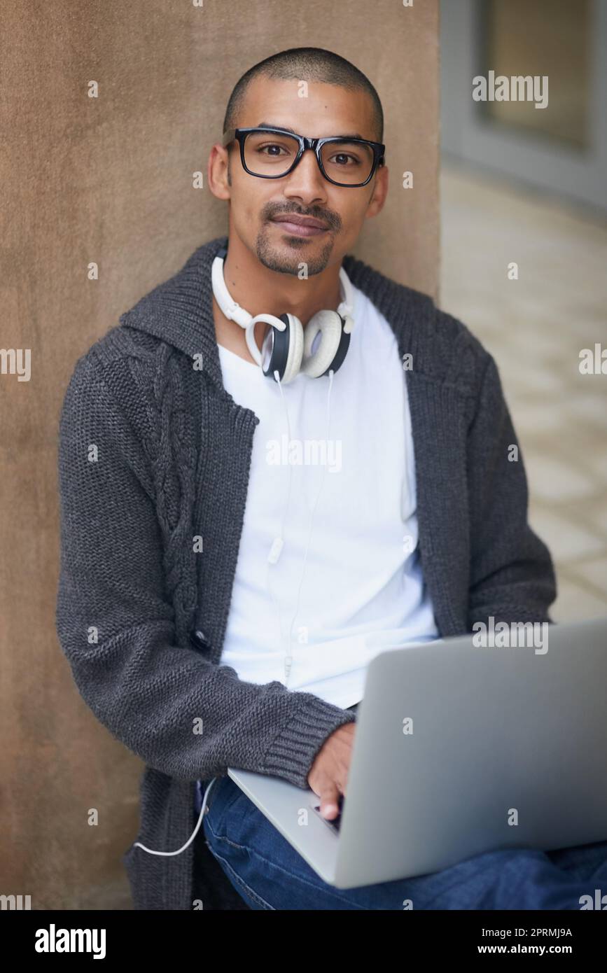 La vita di uno studente. Ritratto di uno studente universitario che utilizza il computer portatile mentre si siede all'esterno del campus. Foto Stock