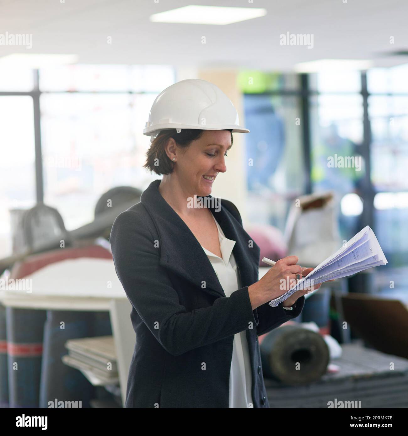 Mi piace molto quando un progetto viene insieme. Una donna di costruzione in loco indossare un elmetto. Foto Stock