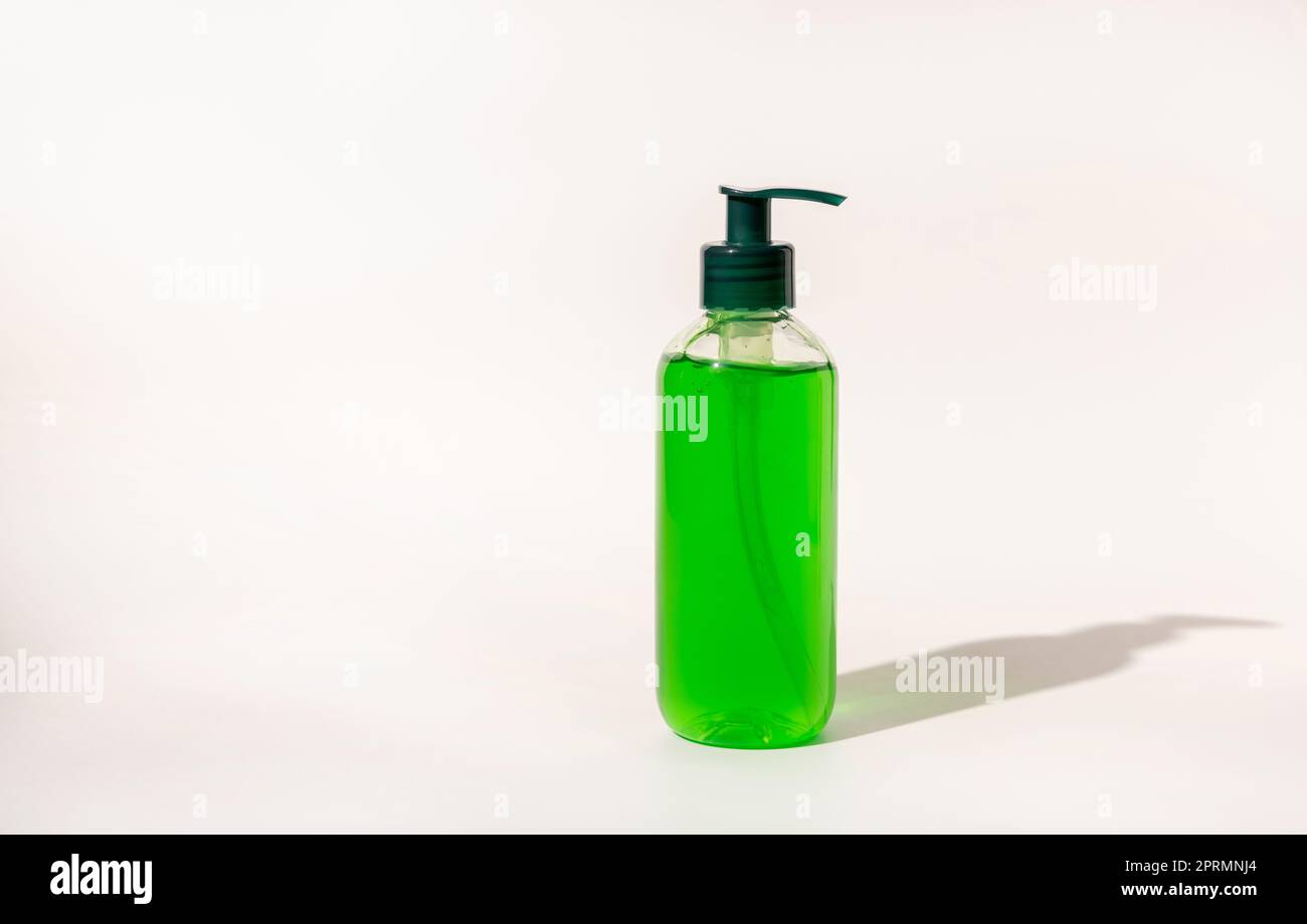 Flacone dispenser per pompa cosmetica riempito con liquido verde su prodotto per la cura della pelle di aloe vera bianco Foto Stock