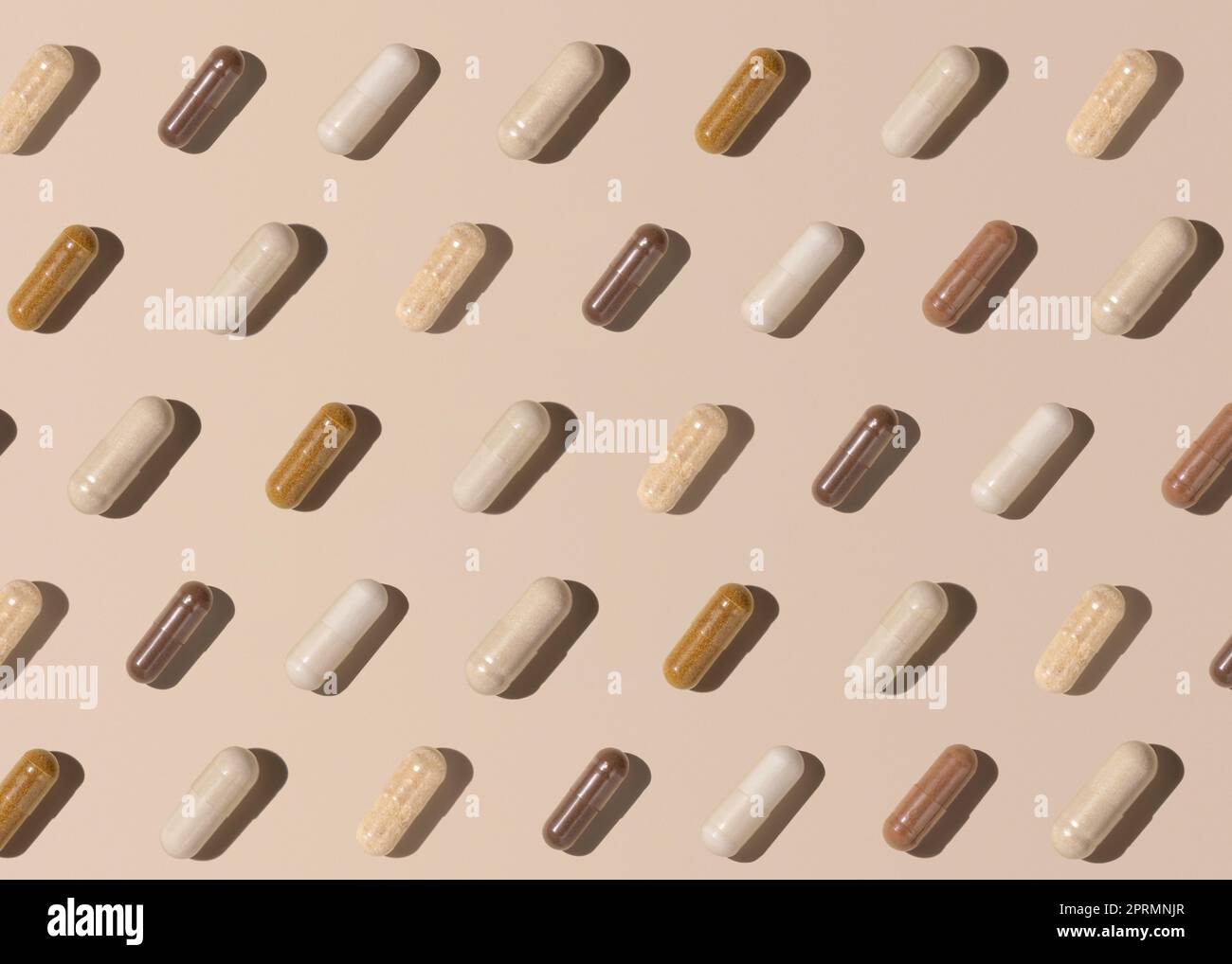 Modello creativo con capsule sulla vista dall'alto beige chiaro, ombre rigide. Assunzione di integratori Foto Stock