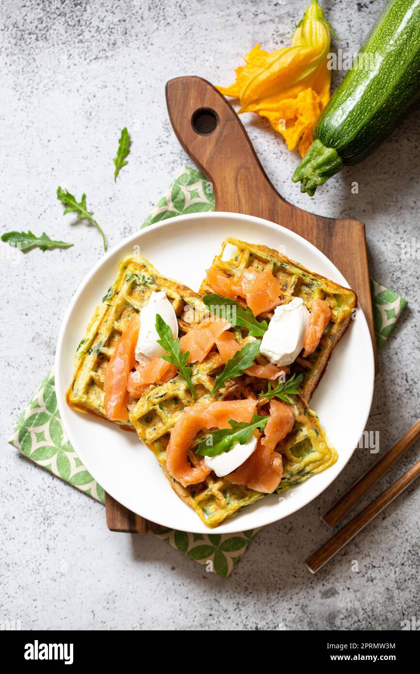 Waffle belgi con zucchine e verdure con formaggio cottage e salmone salato Foto Stock