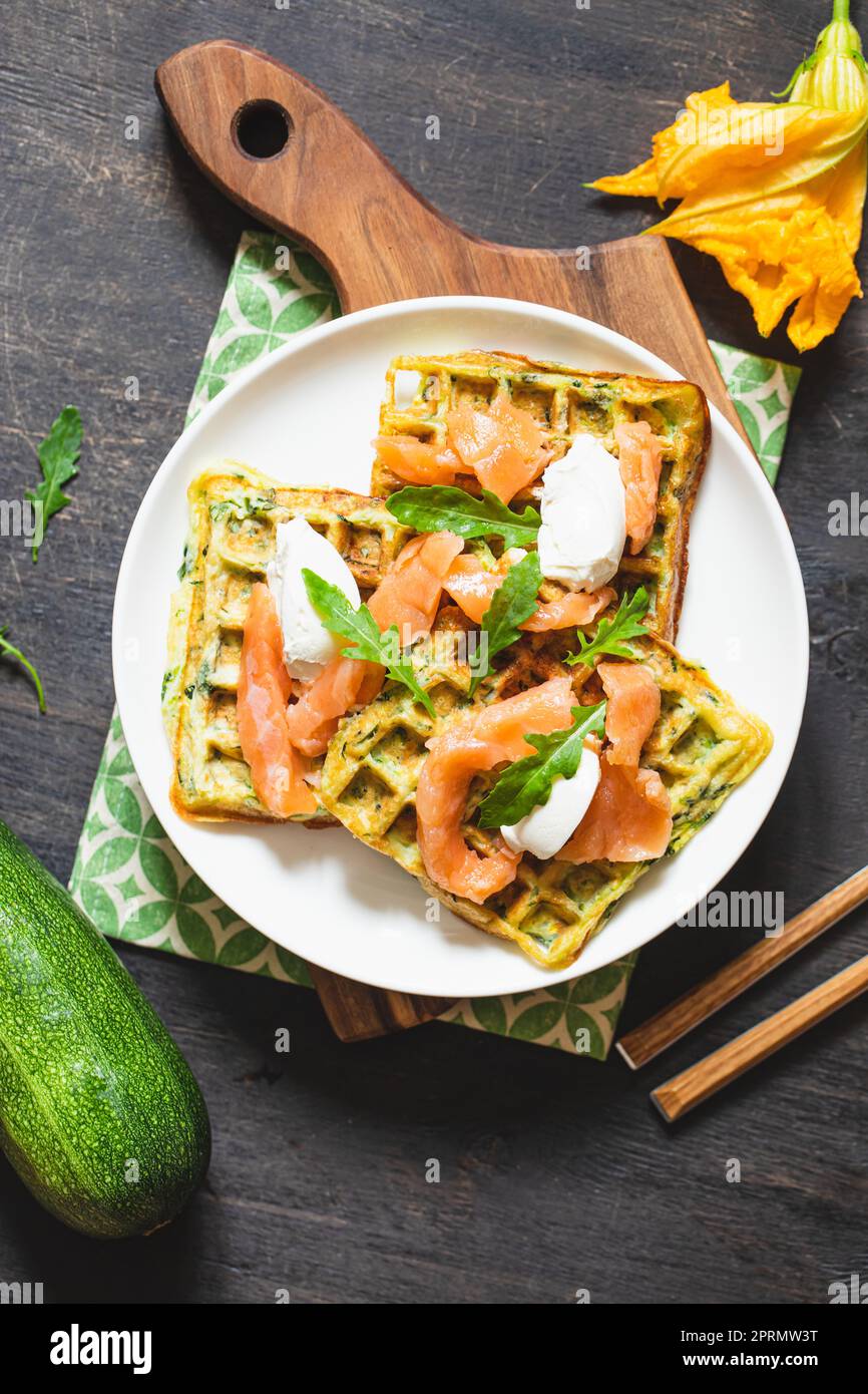 Waffle belgi con zucchine e verdure con formaggio cottage e salmone salato Foto Stock