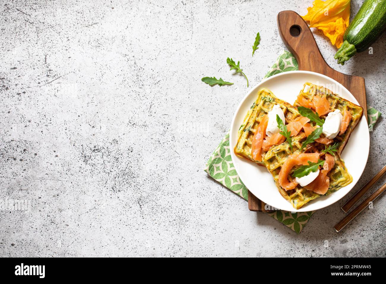 Waffle belgi con zucchine e verdure con formaggio cottage e salmone salato Foto Stock